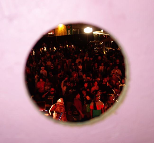 A view of a party down below through a hole in an art piece